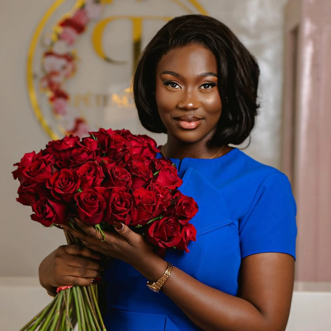 Alima, fondatrice de Pétence Florale, fleuriste à Bamako, avec un bouquet de roses rouges